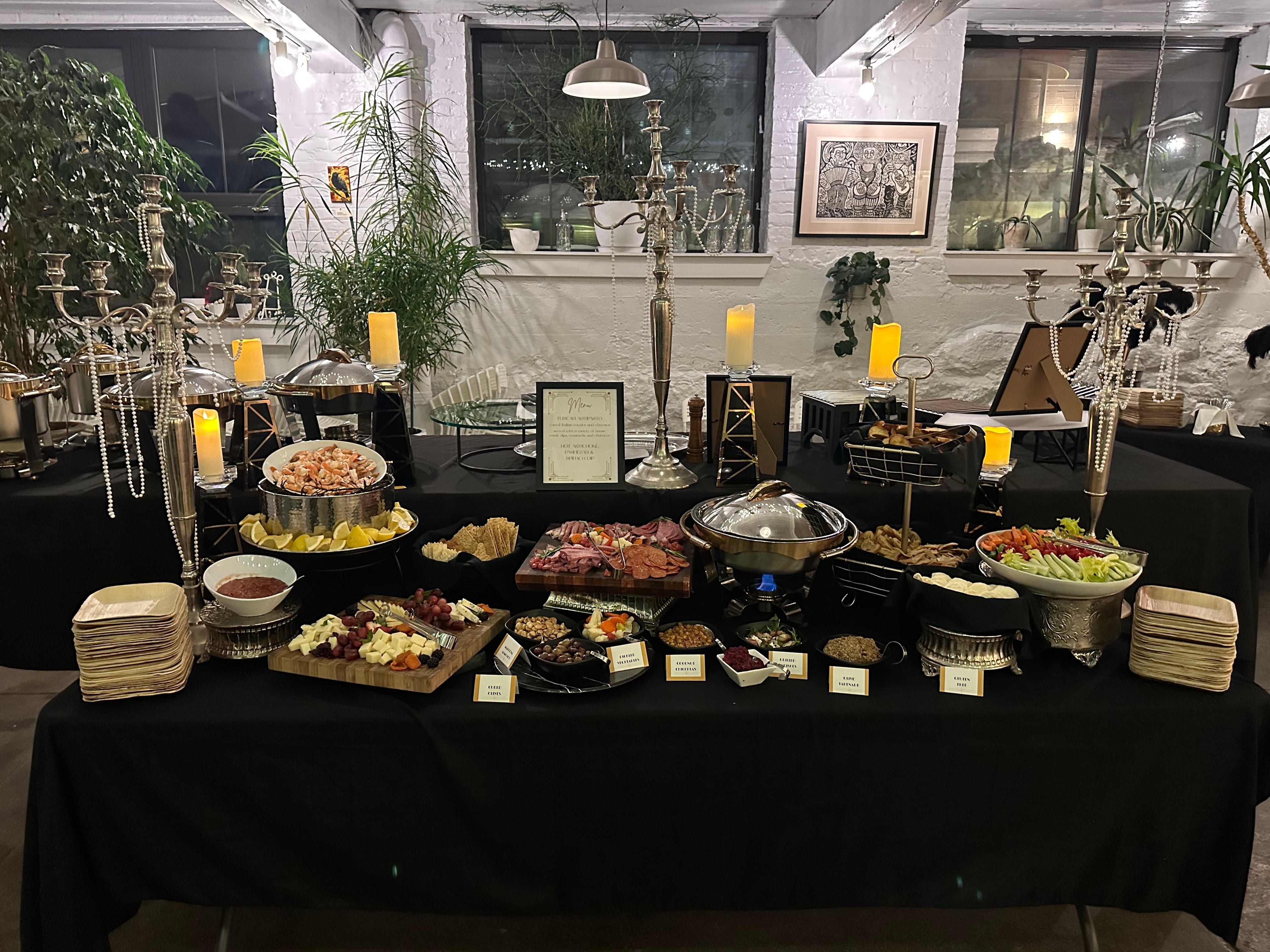 Gatsby-themed evening buffet with candelabras, shrimp cocktail, charcuterie, and silver serving dishes