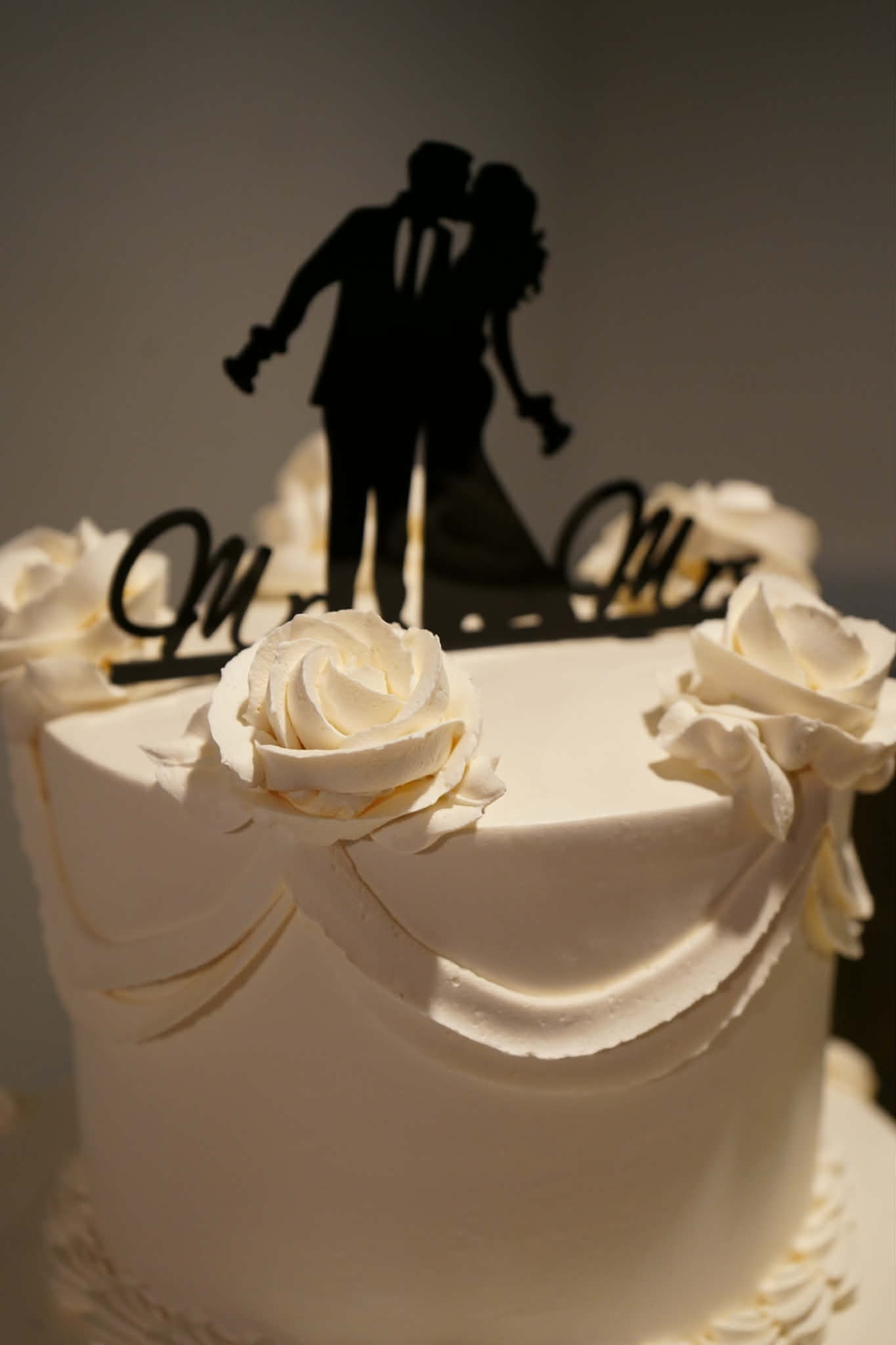Elegant wedding cake with white roses from Emily Moniz's wedding