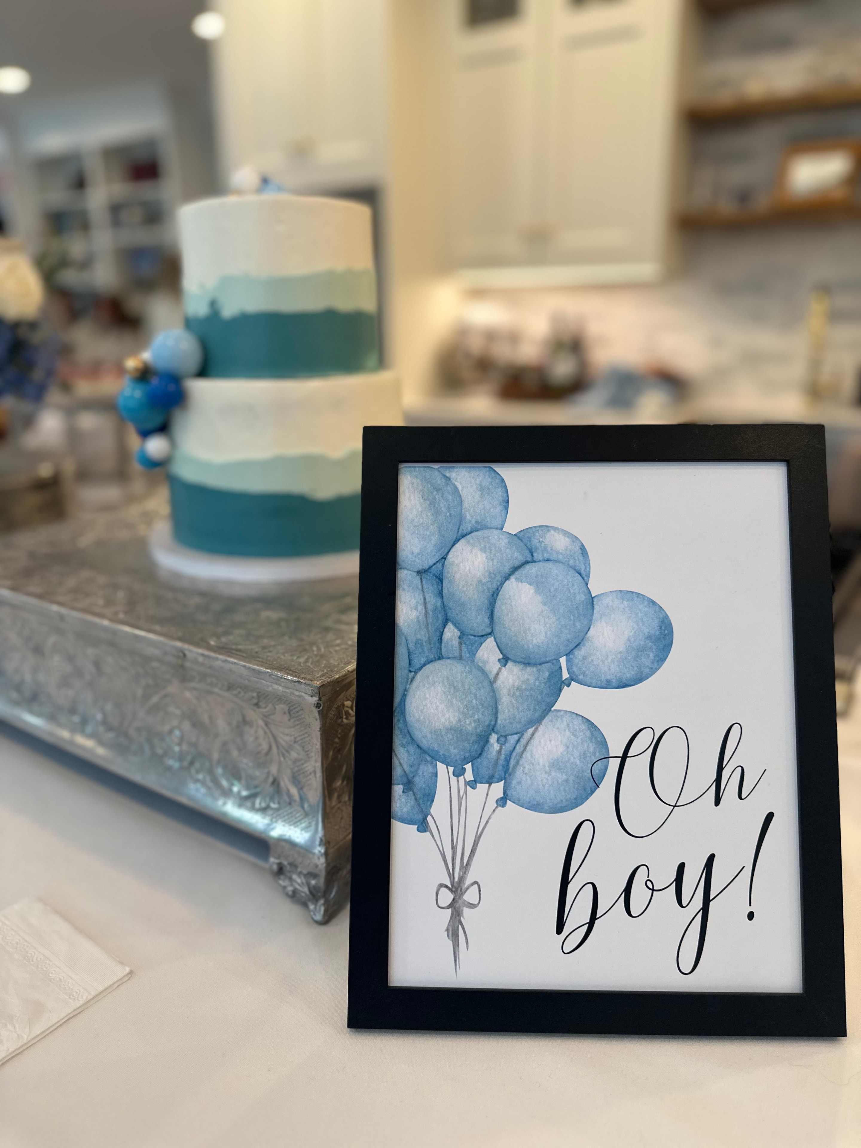 Blue ombre tiered baby shower cake with Oh Boy sign and balloon decor