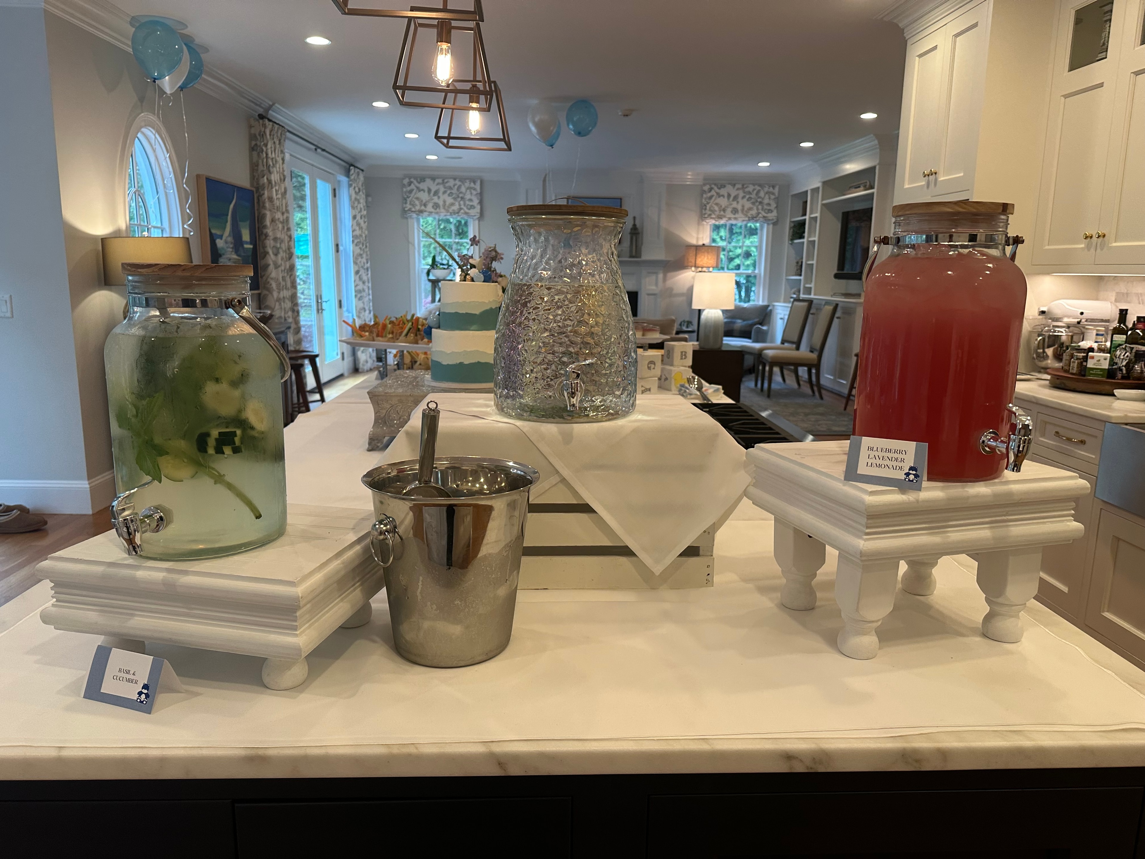 Elegant drink station with infused water, blueberry lavender lemonade, and floral arrangements