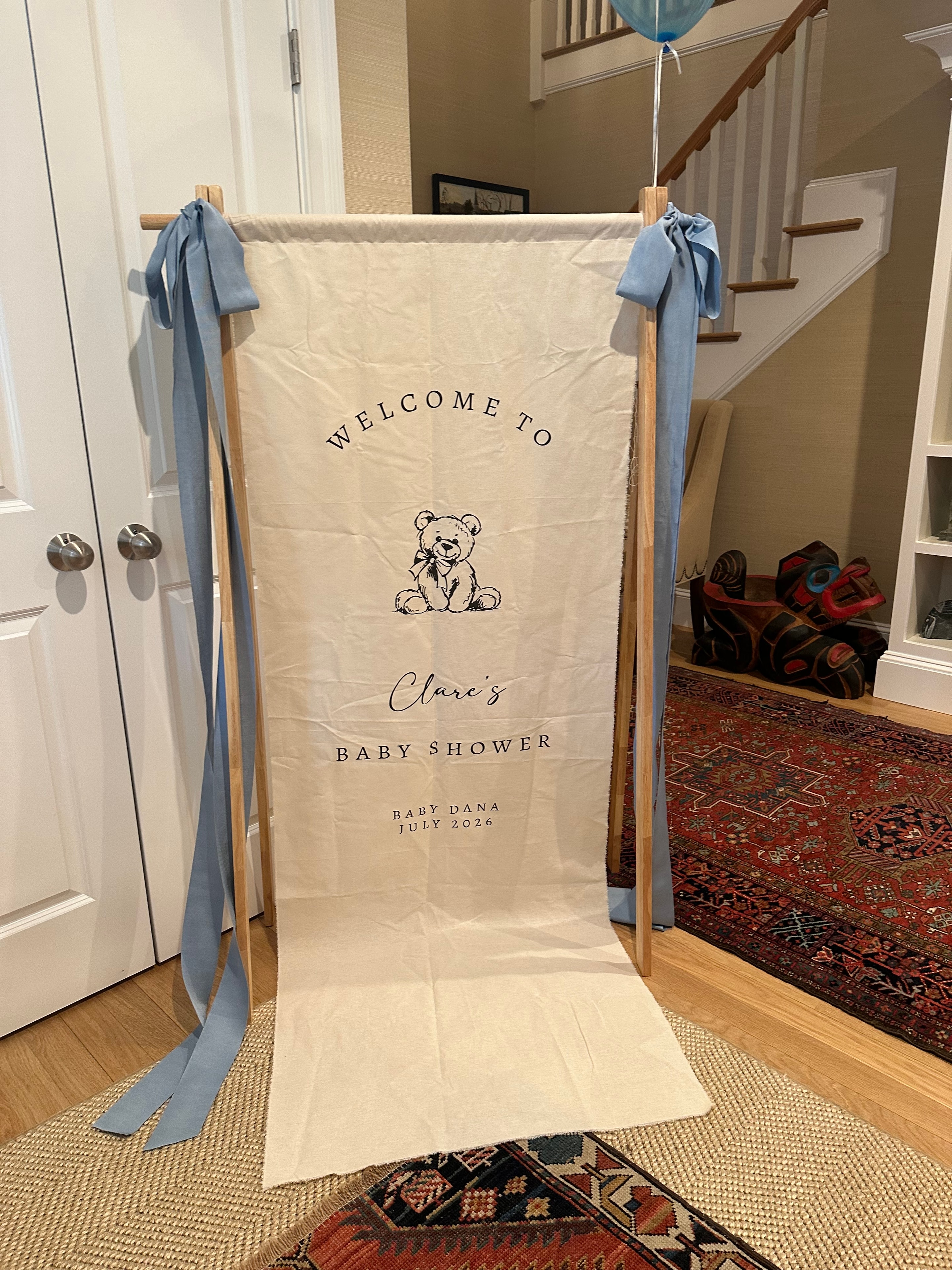 Custom welcome banner for Clare's baby shower with teddy bear design and blue ribbon